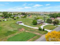 Stunning aerial view of a home with a long driveway, lush greenery, and a detached garage at 15545 Lipan St, Broomfield, CO 80023