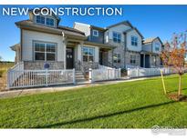 New construction townhomes with stone accents, inviting front porches, and well-manicured lawns at 210 High Point Dr, Longmont, CO 80504