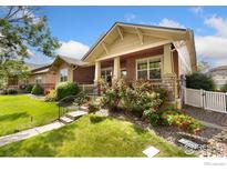 Charming two-story home with a well-manicured lawn and beautiful rose bushes at 336 Olympia Ave, Longmont, CO 80504