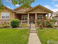 Charming craftsman-style home with a landscaped front yard and inviting front porch at 336 Olympia Ave, Longmont, CO 80504