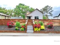 Charming home featuring a wood fence, landscaping, and a welcoming staircase at 4965 Clayton St, Denver, CO 80216