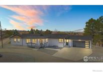 Beautiful home with white brick exterior, well-manicured landscaping, and a two-car garage at 6766 Zenobia Loop, Westminster, CO 80030