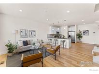 Bright, open-concept living room with hardwood floors and modern decor at 751 Grandview Mdws Dr, Longmont, CO 80503