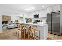 Bright, modern kitchen with white cabinets, stainless steel appliances, and a skylight at 8190 Raleigh Pl, Westminster, CO 80031
