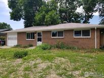 Charming one-story brick home with an attached garage and mature trees in a lovely neighborhood at 829 Hubbard Dr, Longmont, CO 80504