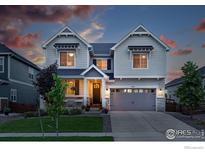 Charming two-story home with a well-manicured lawn and attached two car garage at 952 Pinecliff Dr, Erie, CO 80516