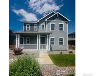 Charming two-story home features a welcoming front porch and well-maintained landscaping at 10604 Reunion Pkwy, Commerce City, CO 80022