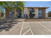 Classic apartment building with a large tree and ample parking spaces at 12172 Melody Dr # 101, Westminster, CO 80234