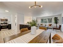 Bright living room area featuring an open layout flowing into the dining and kitchen areas at 12802 E Nevada Cir, Aurora, CO 80012
