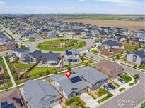 Stunning aerial view of a modern home with solar panels in a well-planned community with green spaces and landscaping at 17871 E 96Th Pl, Commerce City, CO 80022