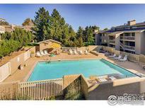 Aerial view of a community pool surrounded by lush greenery and lounge chairs at 20 S Boulder Cir # 2204, Boulder, CO 80303