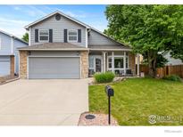 Charming two-story home featuring a two-car garage, stone accents, and a well-manicured front lawn in a suburban neighborhood at 2232 S Yampa Ct, Aurora, CO 80013