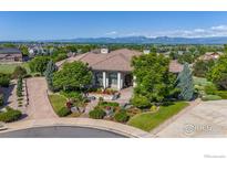 Stunning exterior elevation showcasing a landscaped front yard with mature trees and mountain views at 2378 Plumb Pl, Erie, CO 80516