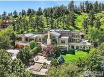 Expansive property featuring multi-level patio with lounge area and fire pit, surrounded by lush landscaping at 45 Bellevue Dr, Boulder, CO 80302