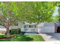 Charming two-story home with a welcoming front porch and well-manicured landscaping at 647 Florence Ave, Firestone, CO 80520