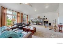 Spacious living room featuring a fireplace, plush seating, and natural light from large windows at 6503 Big Horn Trl, Littleton, CO 80125