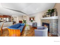 Bright living room features hardwood floors, a stone fireplace, and comfortable seating at 6945 N Fargo Trl, Littleton, CO 80125