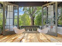 Inviting sunroom boasts wood floors, bright natural light, and french doors to the outdoors at 1217 N Downing St # 4, Denver, CO 80218