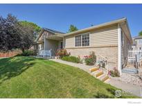 Charming single-story home featuring a well-maintained lawn and beautiful landscaping at 2156 Collyer St, Longmont, CO 80501