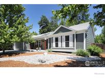 Charming home featuring manicured landscaping, stone accents, gray siding, and white trim at 268 S Buchanan Cir, Louisville, CO 80027
