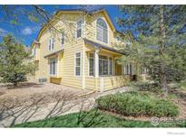 Charming yellow home with large windows and a welcoming front porch nestled among mature trees at 2855 Rock Creek Cir # 233, Superior, CO 80027