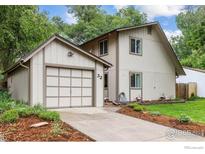 Two-story home featuring an attached garage, neutral paint, and landscaped yard at 32 Powder Horn Pl, Longmont, CO 80504