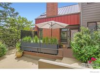 Charming townhome entrance with a brick facade, lush greenery and a cozy outdoor seating area at 780 Walnut St # A, Boulder, CO 80302