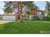 Charming two-story brick home featuring a well-manicured front yard and an attached two-car garage at 8840 Niwot Rd, Niwot, CO 80503
