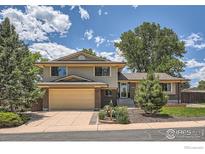 Charming two-story home featuring brick and siding exterior, attached garage, and a well-manicured front yard at 1951 S Deframe Way, Lakewood, CO 80228