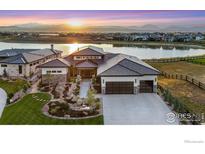 Stunning waterfront home with professional landscaping and mountain views at sunset at 2659 Heron Lakes Pkwy, Berthoud, CO 80513