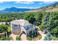 A luxurious home boasts a stucco exterior with a beautiful stone facade, and mountain views at 3747 Mountain Laurel Pl, Boulder, CO 80304