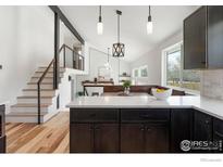 Bright kitchen features a large island, modern pendant lighting, and an open floor plan with hardwood flooring at 4223 Peach Way, Boulder, CO 80301
