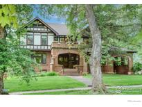 Charming two-story home with a brick facade, covered porch and well-maintained lawn at 604 Mapleton Ave, Boulder, CO 80304