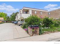 Multi-Gathering home with brick and siding, lush greenery, colorful flowers, and convenient parking at 911 Tulip St # C, Longmont, CO 80501