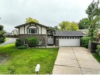Charming two-story home with brick accents, a well-manicured lawn, and an attached two-car garage at 9642 Meade Ct, Westminster, CO 80031