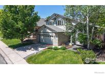Charming two-story home featuring a well-maintained lawn, mature trees, and a two-car garage at 13673 Cook St, Thornton, CO 80602
