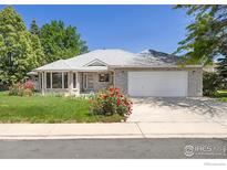 Charming one-story home featuring a well-maintained lawn, lovely landscaping, and an attached two-car garage at 1448 16Th Ave, Longmont, CO 80501