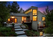 Inviting exterior featuring a multi-level deck, lush landscaping, and stunning architectural design in a serene wooded setting at 178 Balsam Ln, Boulder, CO 80304