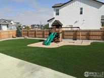 Fully fenced backyard featuring artificial turf and a playset at 348 Vista Cliff Ct, Castle Rock, CO 80104
