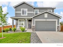 Charming two-story home showcasing a well-manicured lawn, inviting front porch with rocking chairs and a two car garage at 348 Vista Cliff Ct, Castle Rock, CO 80104