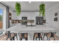 Bright kitchen features white cabinets, a large island, and modern appliances at 348 Vista Cliff Ct, Castle Rock, CO 80104