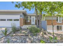 Charming home featuring a well-manicured lawn, brick accents, and a two-car garage at 540 Ithaca Dr, Boulder, CO 80305