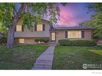 Charming split-level home with a well-maintained lawn and mature shade tree in front yard at 11797 Keough Dr, Northglenn, CO 80233