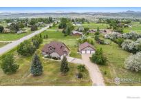 Sprawling property with a two-story home, large garage, and scenic views of rolling hills and distant mountains at 1625 Green Ridge Rd, Berthoud, CO 80513