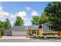 Charming home with solar panels, a two-car garage and a welcoming yellow door at 2016 Strathmore St, Louisville, CO 80027