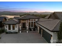 Stunning modern home with a well manicured lawn featuring mountain and lake views at 3095 Heron Lakes Pkwy, Berthoud, CO 80513