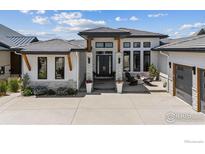 Beautifully modern single-story home with a tile roof, stone accents and a welcoming front entrance at 3095 Heron Lakes Pkwy, Berthoud, CO 80513