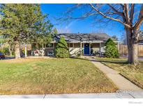 Charming single-story home featuring a well-maintained lawn, mature trees, and a welcoming blue front door at 3200 S Grape St, Denver, CO 80222