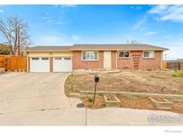 Charming brick ranch-style home featuring a two-car garage and well-kept front yard at 7162 Quay St, Arvada, CO 80003