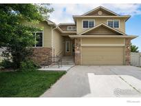 Charming two-story home with stone accents, a two-car garage, and a well-maintained front yard at 9673 Roadrunner Ave, Firestone, CO 80504